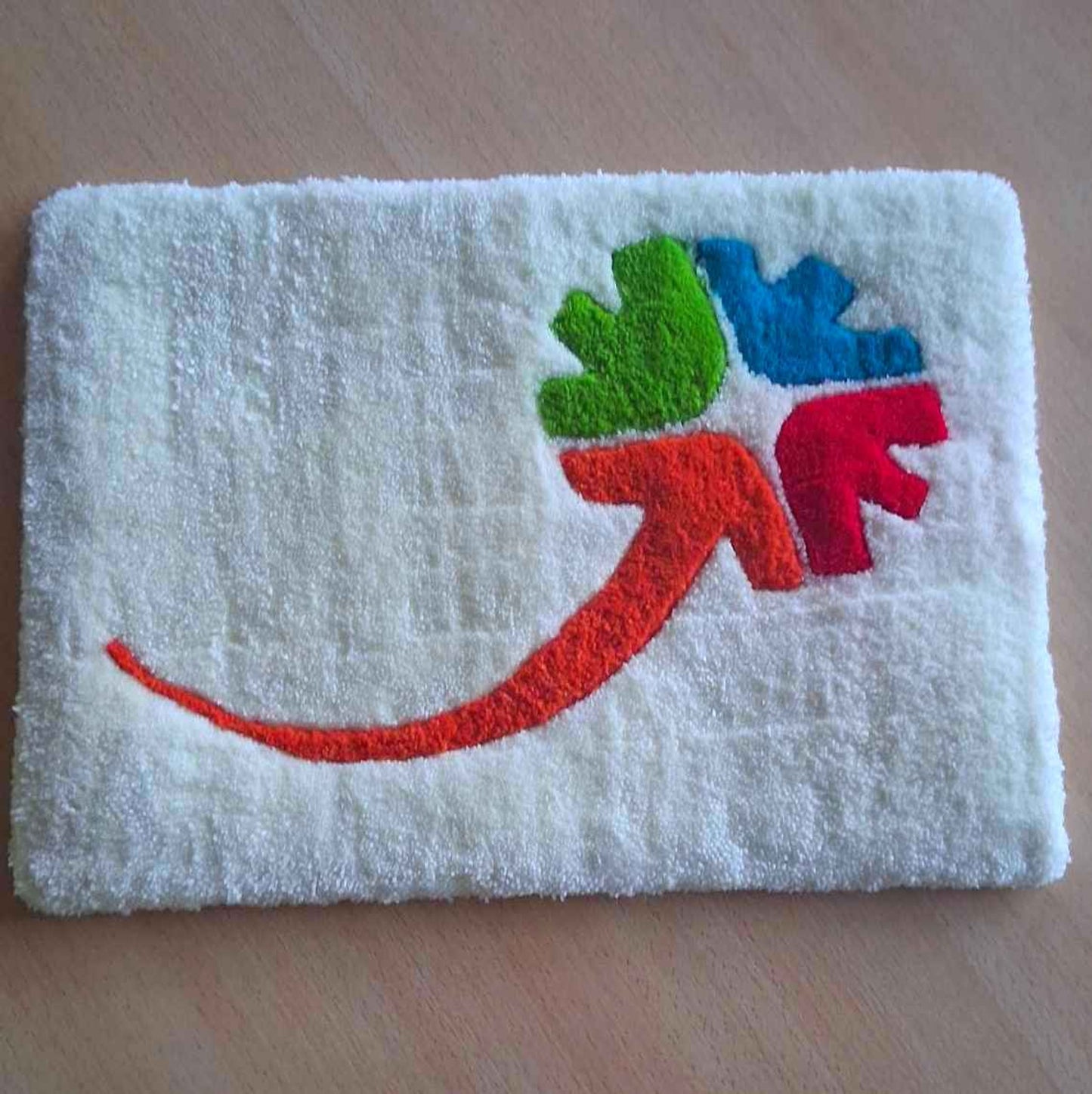 Tapis mural représentant le logo de l'association Transition réalisée lors d'un atelier Tufting collectif avec les salariés de l'association.