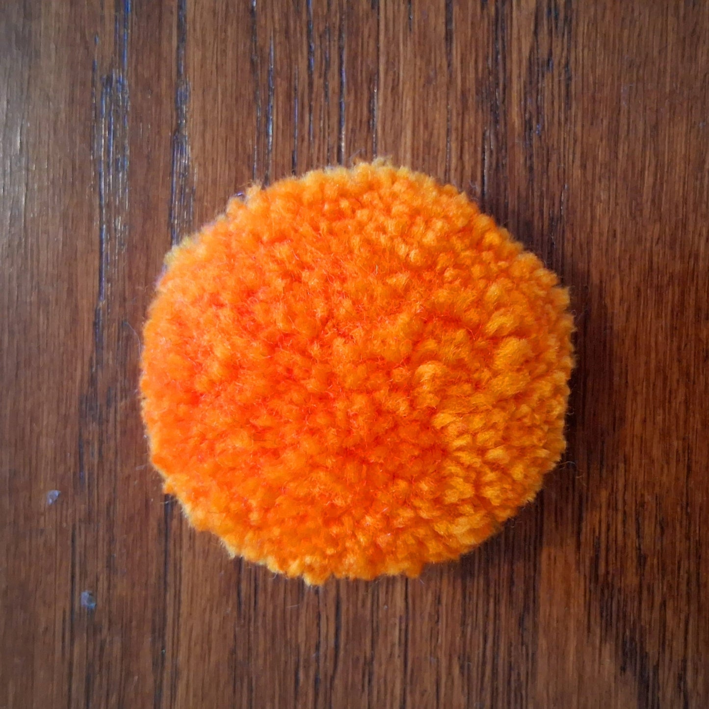 Broche tuftée créée par La Balmo Tufting. Cette broche est munie d'une attache au dos pour être fixée à votre veste ou votre sac. Laine acrylique orange