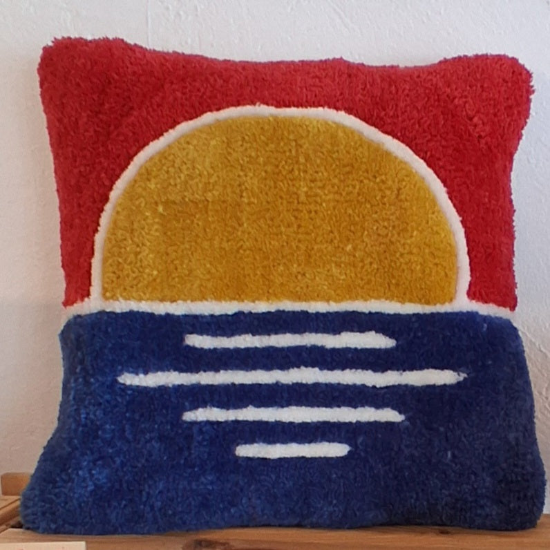 Coussin tufté en laine acrylique représentant un coucher de soleil coloré, apporte de la douceur à ta déco