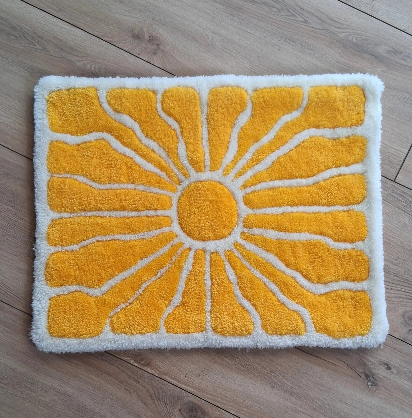 Zoom sur une décoration murale représentant un soleil dans le style japonais, créée par La Balmo Tufting. Laine acrylique jaune et blanche