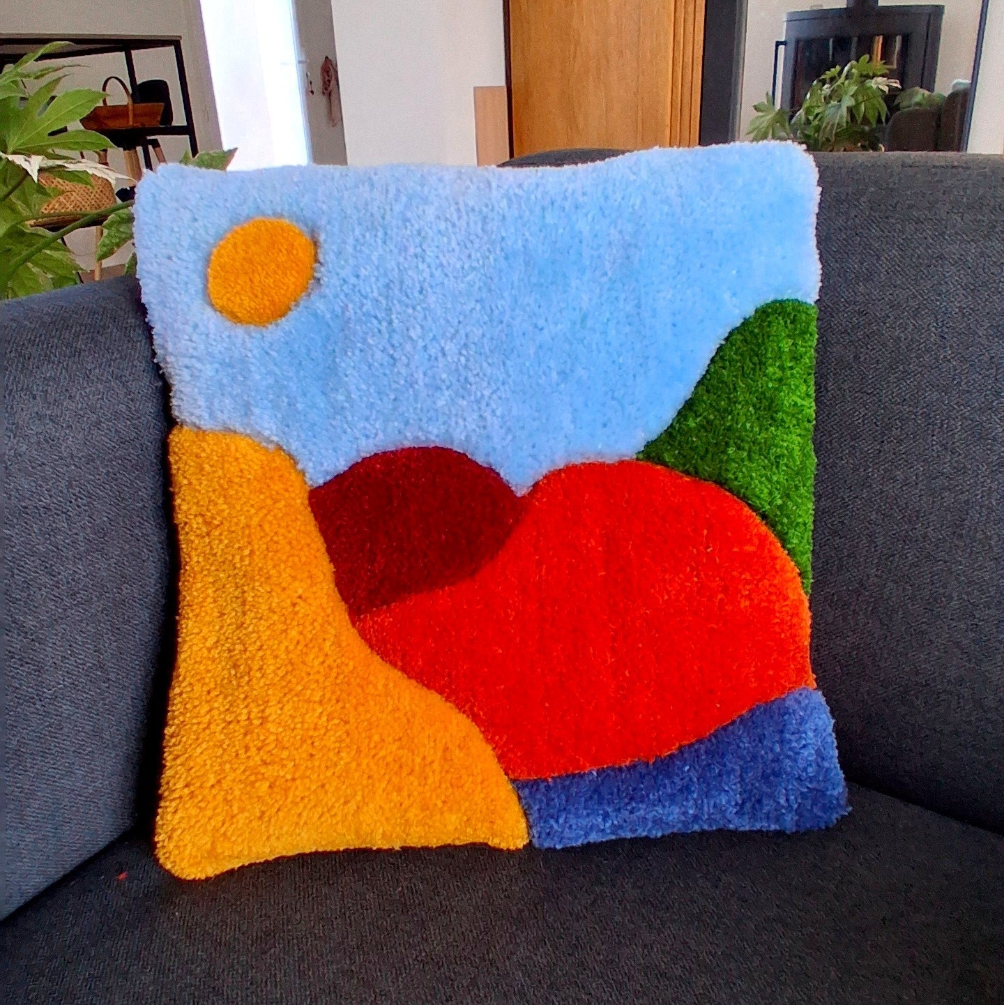 Coussin tufté aux couleurs vives, avec un motif de montagne