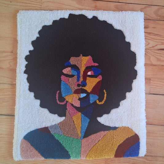 Décoration murale représentant un portrait d'une femme noire, créée par La Balmo Tufitng. Laine acrylique multicolore