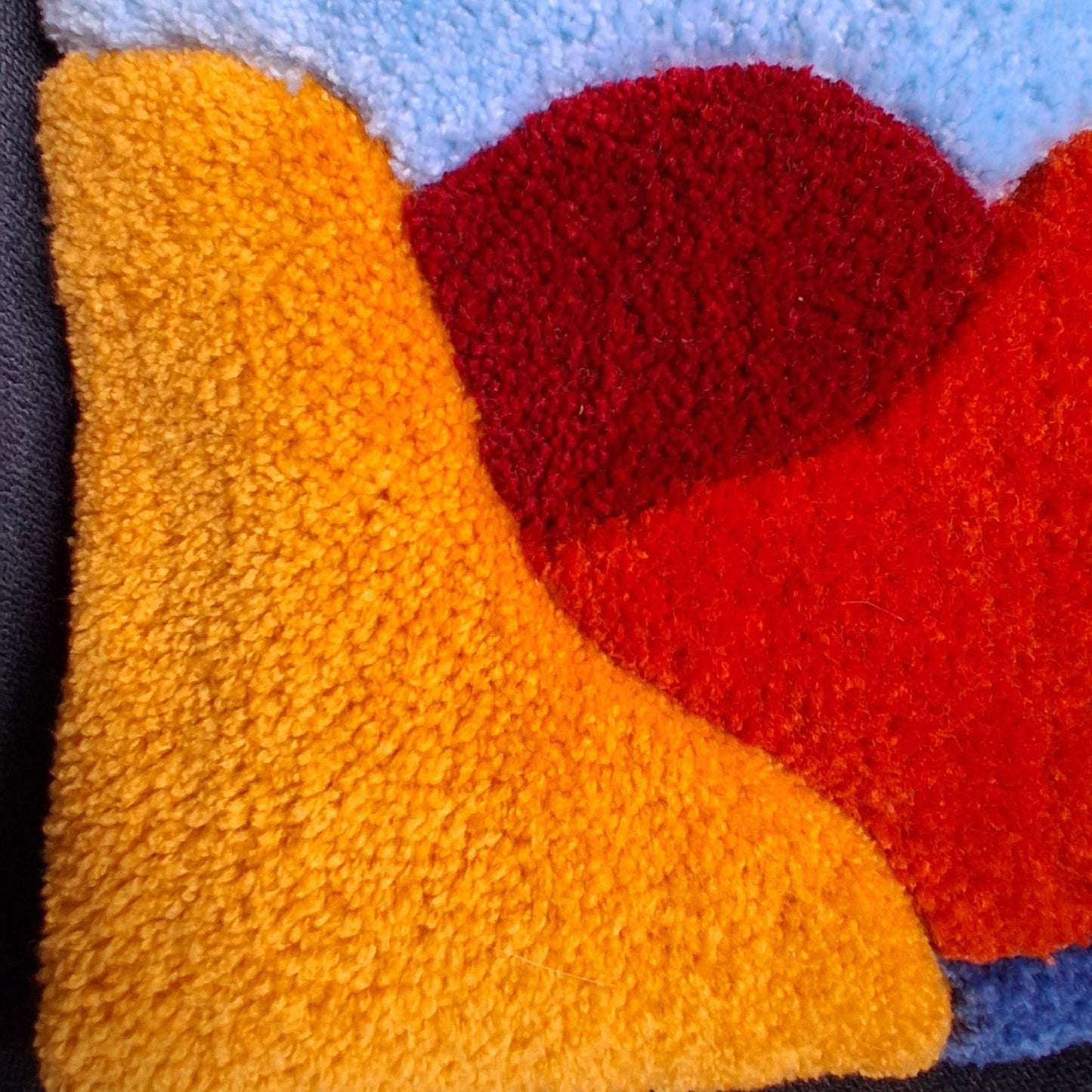 Coussin tufté MENDIA par La Balmo Tufting, coloré jaune blanc, orange, bleu, vert et rouge. Made in 64 Oloron. Décoration originale et artisanale.