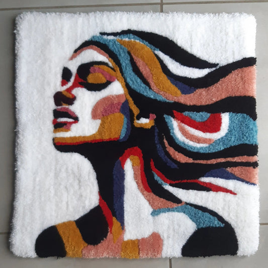 Zoom sur une décoration murale représentant un portrait d'une femme, créée par La Balmo Tufitng. Laine acrylique multicolore