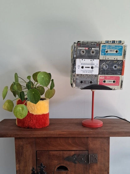 Cache-pot tufté sur un meuble en bois au côté d'une lampe de salon