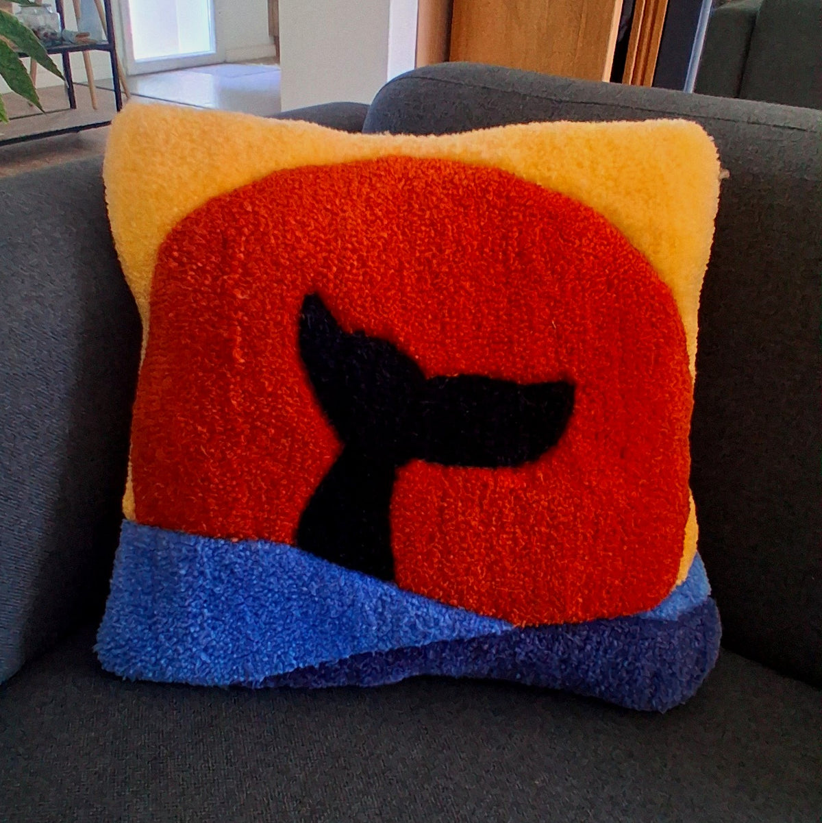 Coussin tufté en laine acrylique avec une queue de baleine plongeant sous un soleil flamboyant