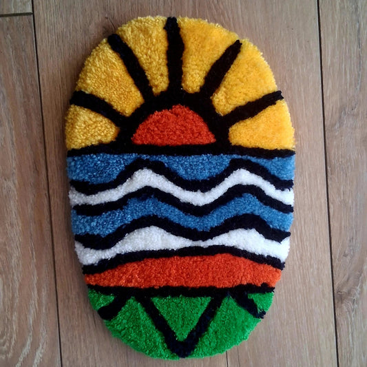 Décoration murale ALOHA représentant un coucher de soleil, créée par La Balmo Tufting. Laine acrylique multicolore