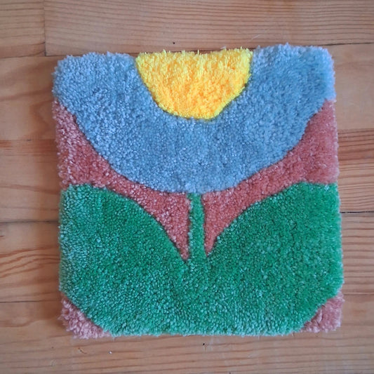 Décoration murale représentant une fleur, créée par La Balmo Tufitng. Laine acrylique multicolore