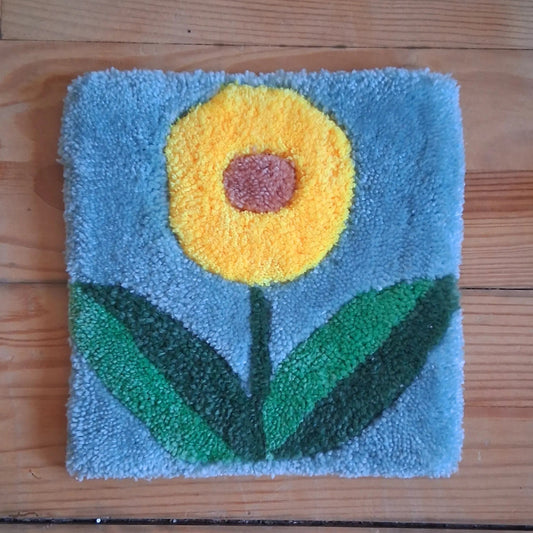 Décoration murale représentant une fleur, créée par La Balmo Tufitng. Laine acrylique multicolore