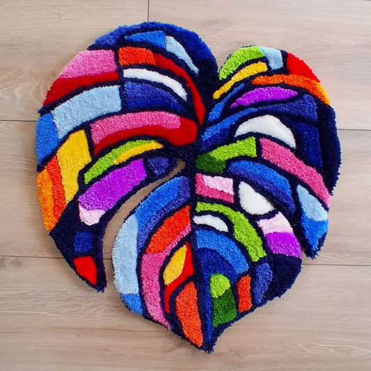 Décoration murale représentant une feuille de monstera multicolore, créée par La Balmo Tufting. Laine acrylique multicolore