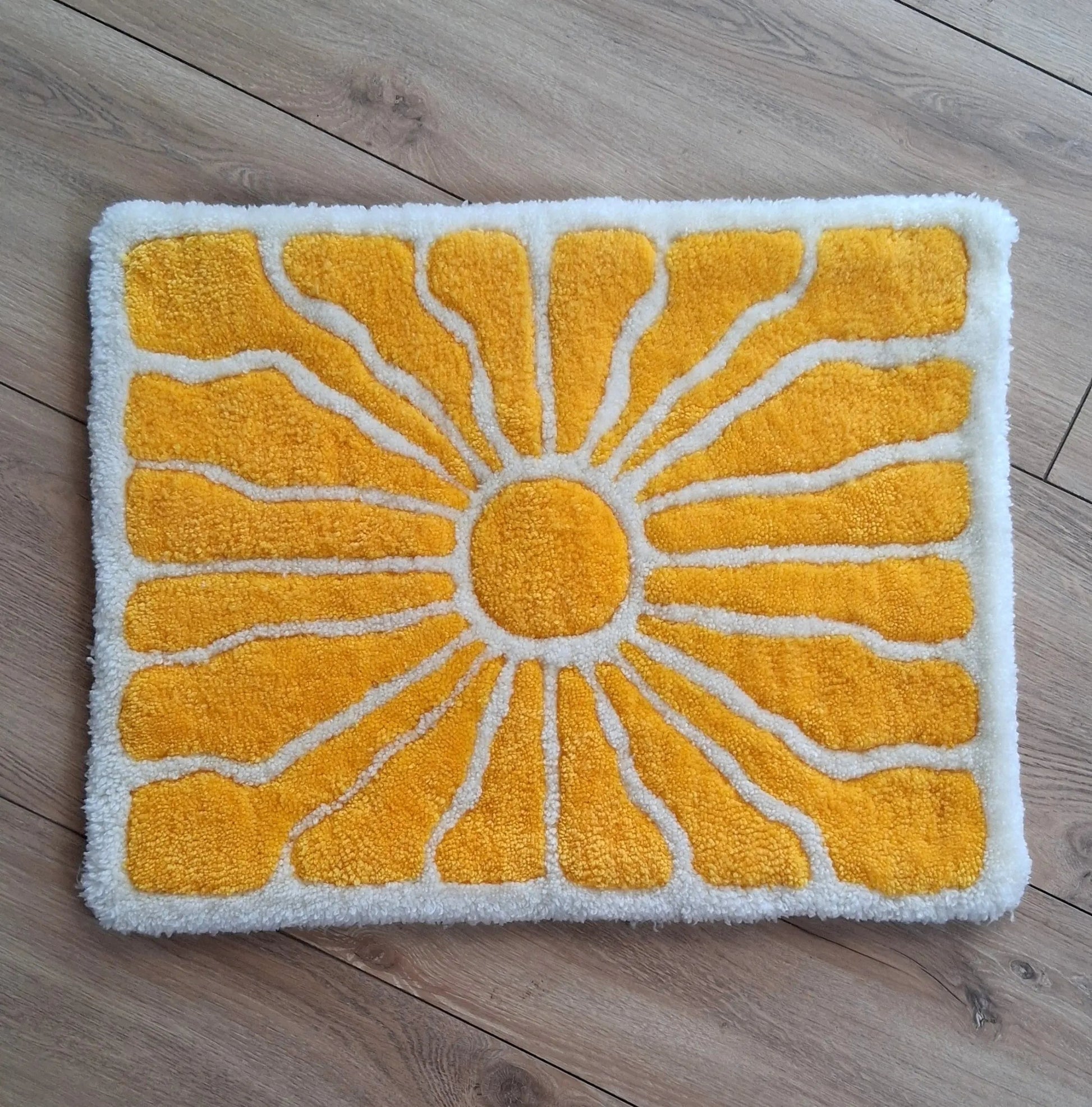 Zoom sur une décoration murale représentant un soleil dans le style japonais, créée par La Balmo Tufting. Laine acrylique jaune et blanche