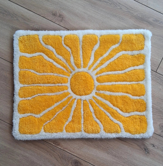 Zoom sur une décoration murale représentant un soleil dans le style japonais, créée par La Balmo Tufting. Laine acrylique jaune et blanche
