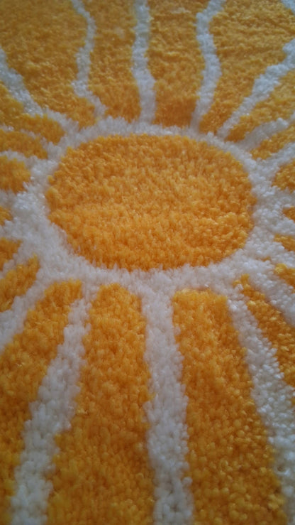 Zoom sur une décoration murale représentant un soleil dans le style japonais, créée par La Balmo Tufting. Laine acrylique jaune, blanche