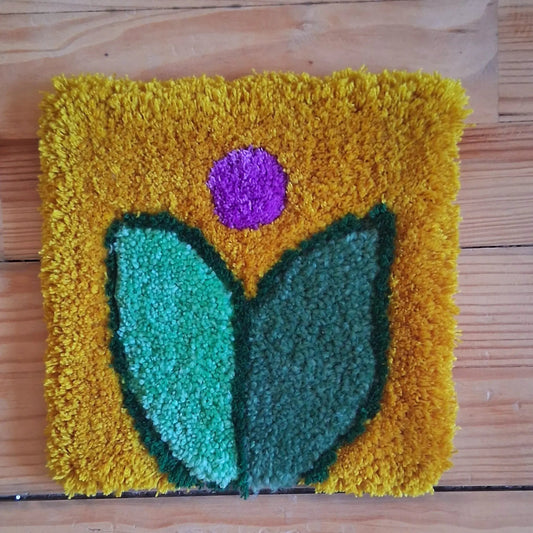 Décoration murale représentant une fleur, créée par La Balmo Tufitng. Laine acrylique multicolore
