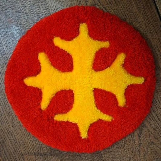 Tufting mural avec la croix occitane, aux couleurs vives rouge et jaune.